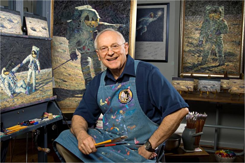 Alan Bean in his artist's workshop with his paintings.